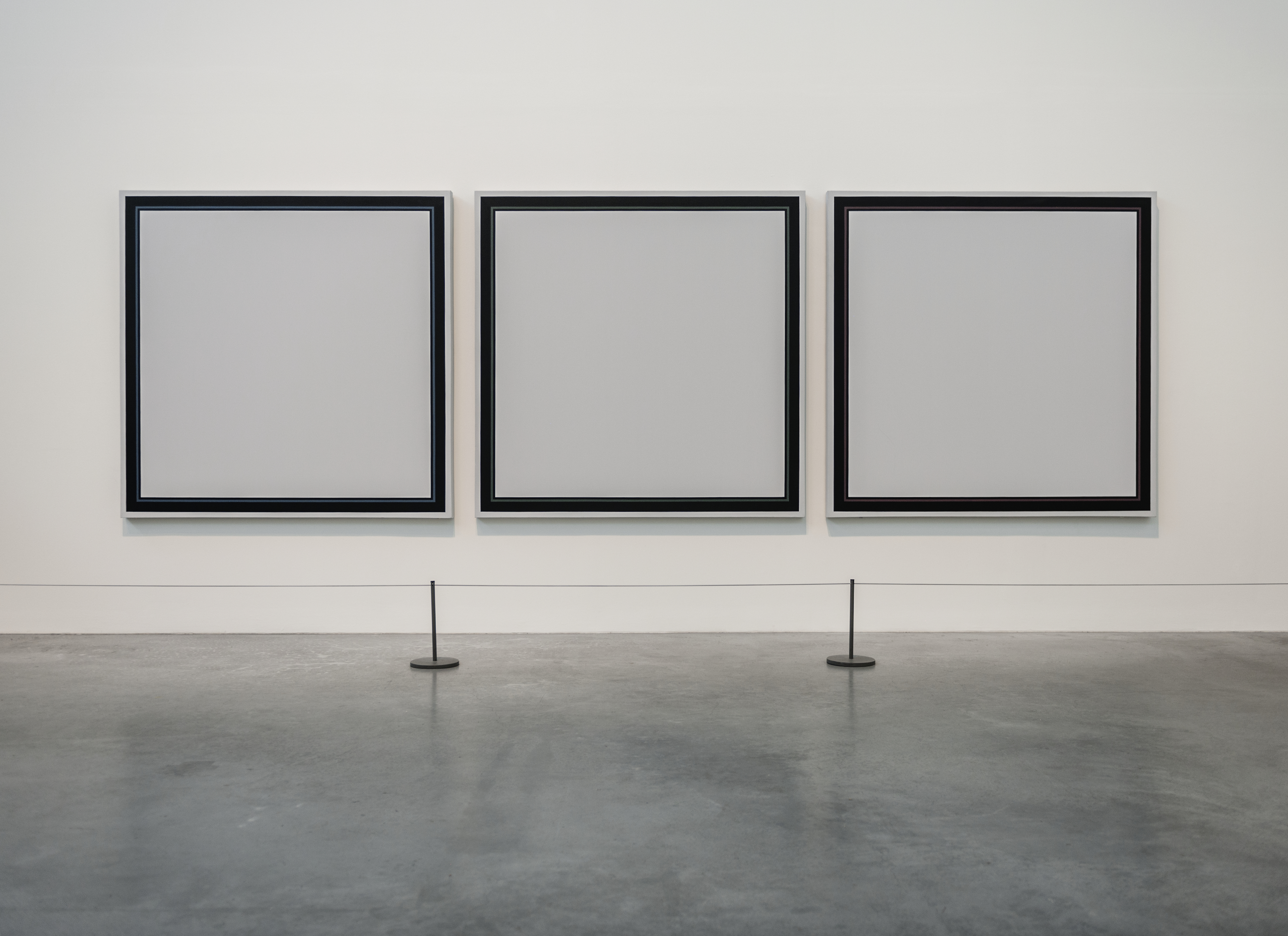 Picture of empty art frames on a gallery wall.