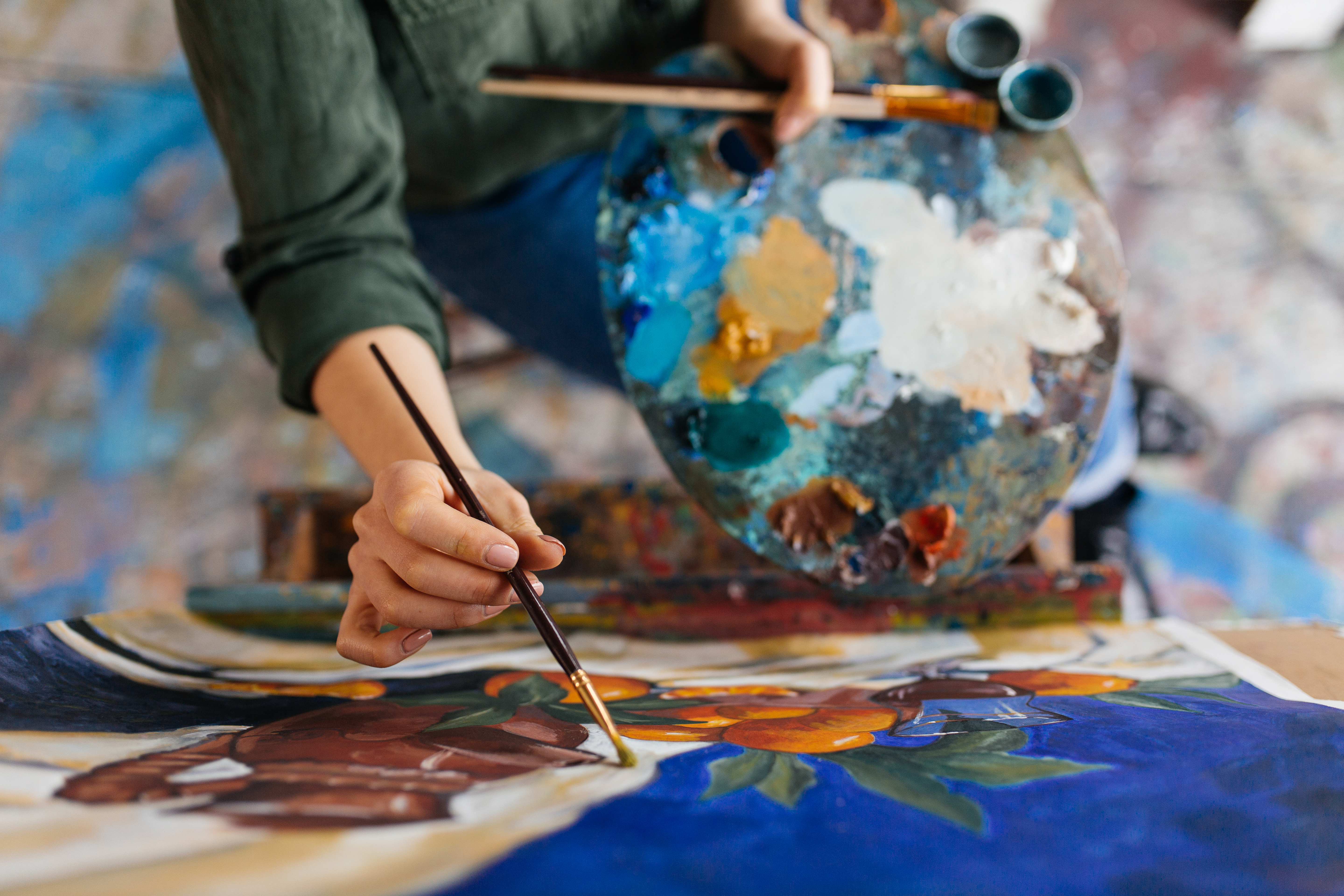 Close up of an artist with a paint pallete and brush