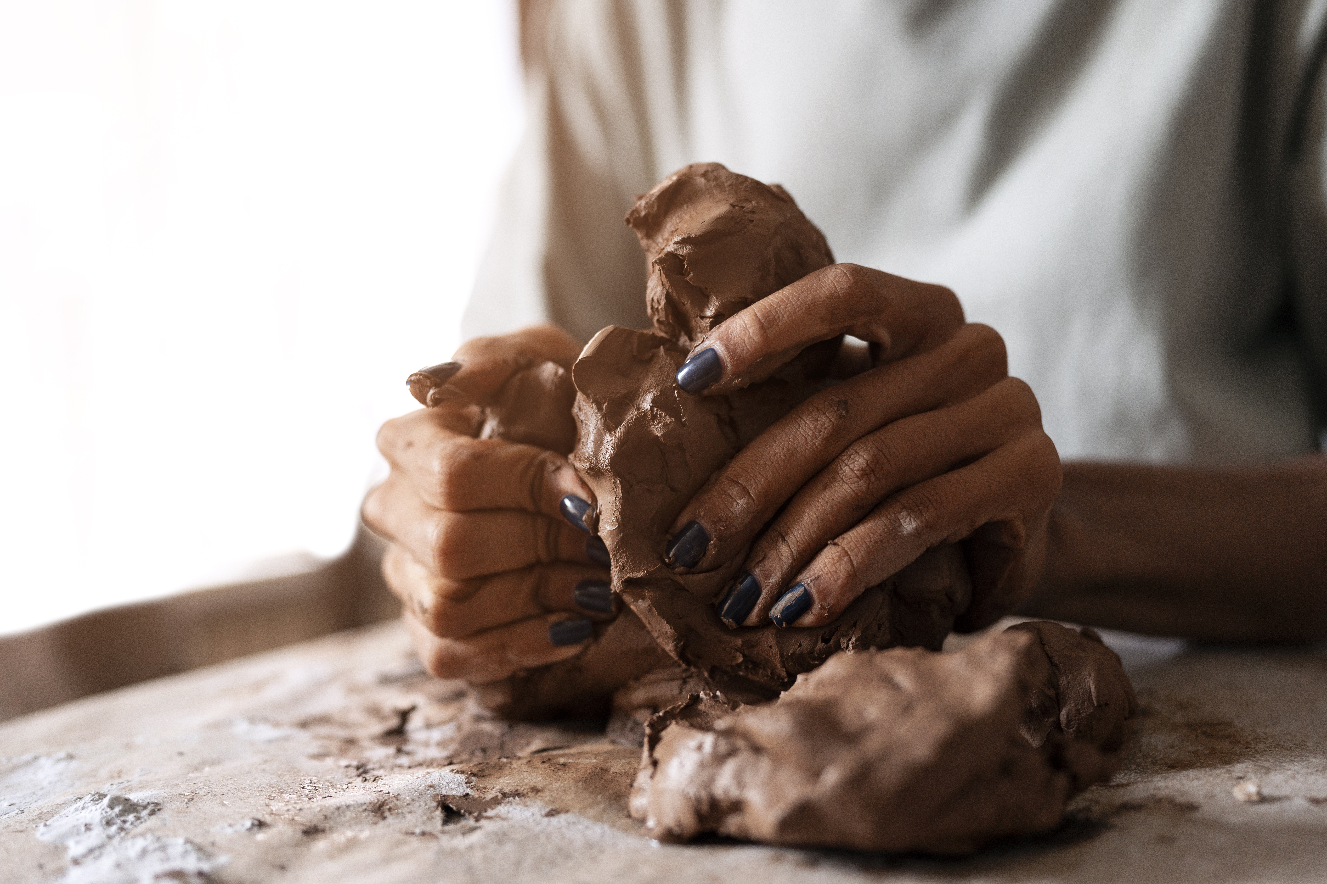 A potter throws clay on a pottery wheel.